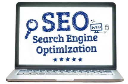 A laptop screen displaying the title SEO in Big and Search Engine Optimization. Also a magnifier is shown to the left and to the right we can see a tiny screen and a mouse. This tiny screen displays the word WEB